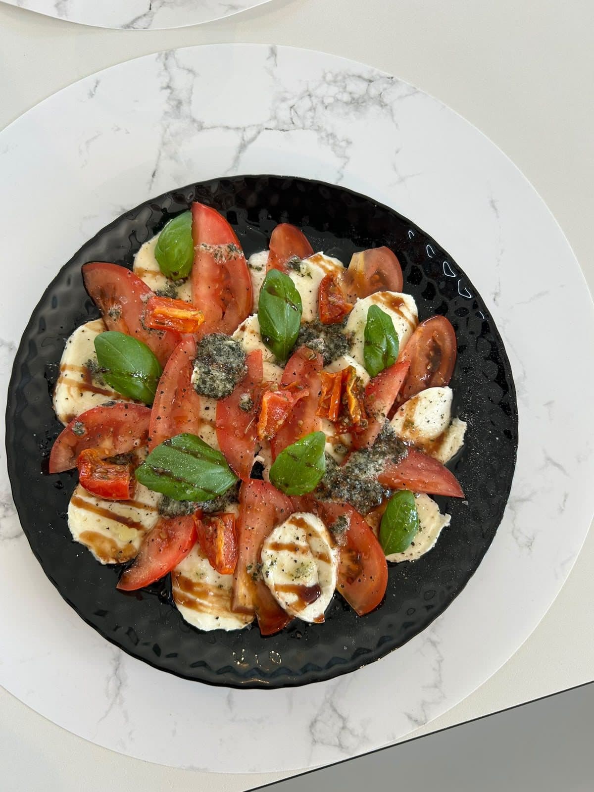 Une assiette de tomates, mozzarella et basilic.